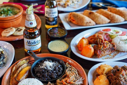A vibrant spread of Mexican dishes, including tacos, beans, rice, and drinks, showcasing a colorful and appetizing meal.