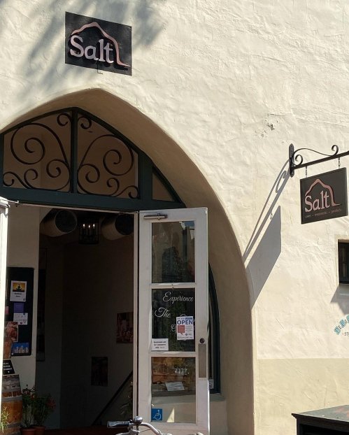 Entrance of a shop named "Salt," featuring an open door and a sign indicating it's open for business.