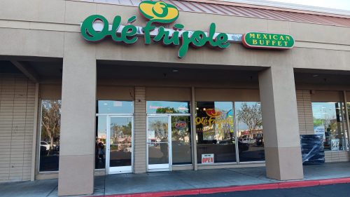 Exterior of Olé Frijole Mexican Buffet, featuring a colorful sign and large glass doors, with an "Open" sign visible.