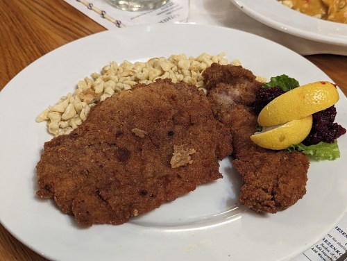 A plate featuring fried chicken, a side of macaroni, and garnished with lettuce and lemon slices.