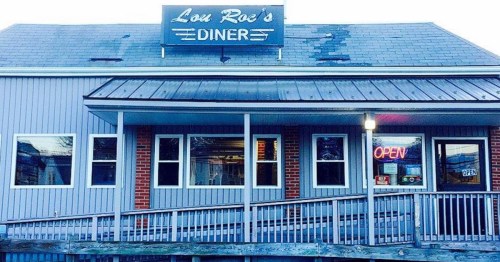 Exterior of Lou Roe's Diner, featuring a sign, open neon light, and a wooden ramp leading to the entrance.