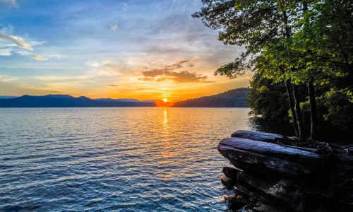 Beautiful early morning sunrise over Lake Jocassee in South Carolina, with calm water reflecting colorful sky hues.
