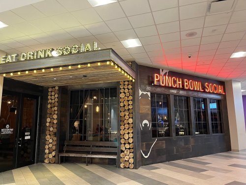 Entrance to Punch Bowl Social, featuring a rustic design with wooden accents and bright signage.
