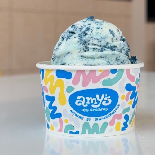 A cup of blue and white ice cream with a colorful, patterned design featuring "Amy's Ice Creams" on the front.
