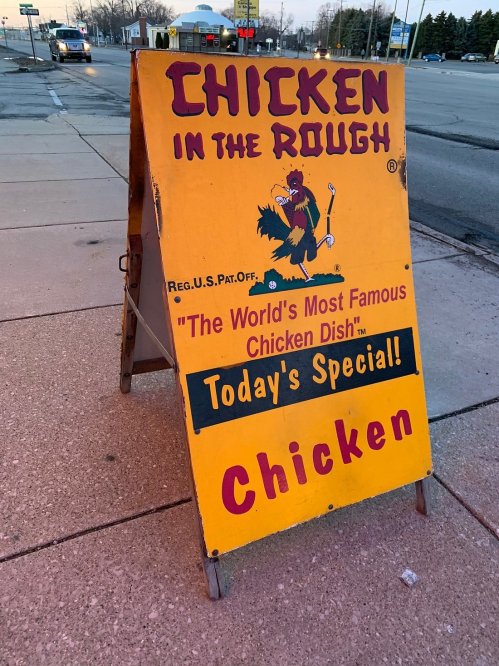 A colorful sign advertising "Chicken in the Rough," featuring a chicken mascot and promoting today's special: chicken.