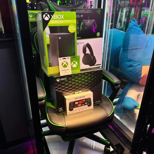 An Xbox console, headset, and controller displayed on a gaming chair in a colorful gaming setup.