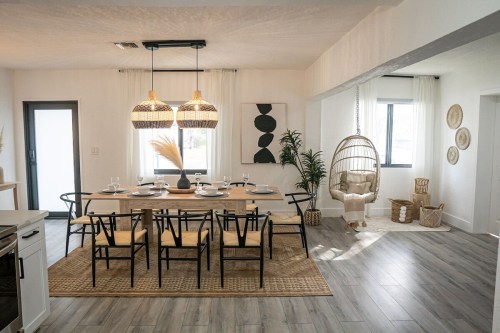 A modern dining area with a large table, stylish chairs, pendant lights, and a cozy seating nook.