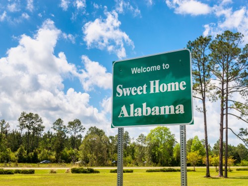 Welcome to Sweet Home Alabama’ road sign on Interstate 10 near the Alabama-Florida border in Robertsdale, USA.