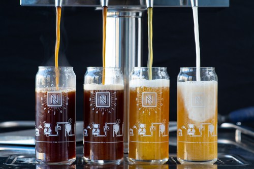 Four glasses of beer in varying colors, being poured from taps, with a stylish logo on each glass.