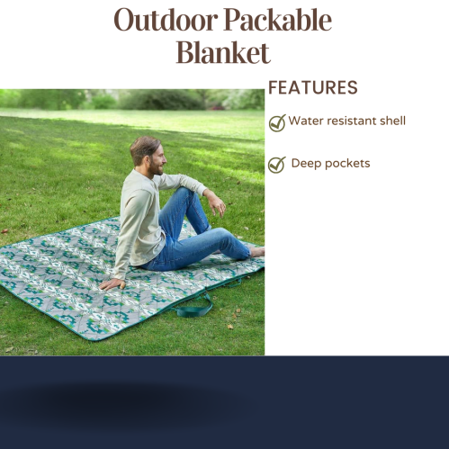 A man sits on a patterned outdoor blanket, showcasing its water-resistant shell and deep pockets.