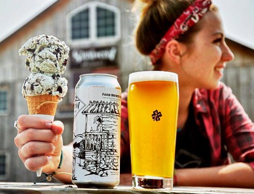 A woman holds an ice cream cone and a beer glass, with a rustic building in the background.