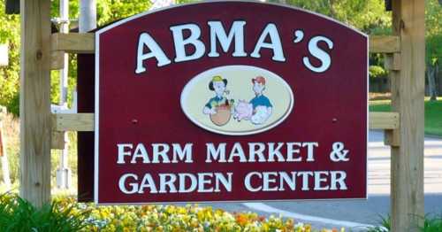 Sign for Abma's Farm Market & Garden Center featuring colorful graphics of a farmer and animals.