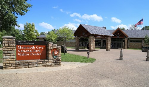 Mammoth Cave National Park Visitor Center entrance with stone architecture and an American flag.