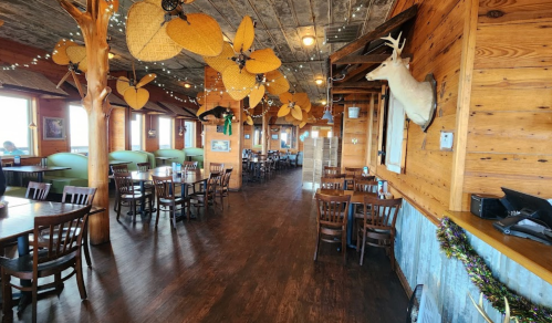 Cozy restaurant interior with wooden decor, tables, and unique ceiling fans, creating a warm, inviting atmosphere.
