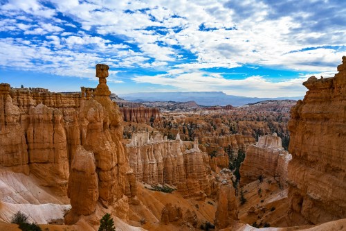 A stunning view of Bryce Canyon's unique rock formations under a blue sky with scattered clouds.