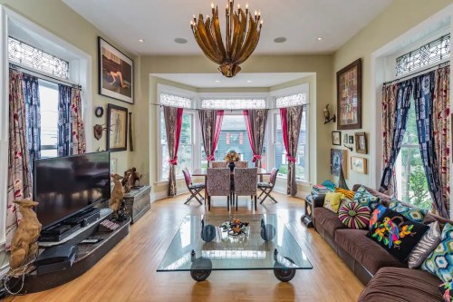 Bright living room with large windows, stylish decor, a glass coffee table, and a cozy seating area.