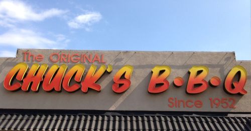 Sign for "The Original Chuck's B.B.Q" with a bright orange and yellow design, established in 1952.
