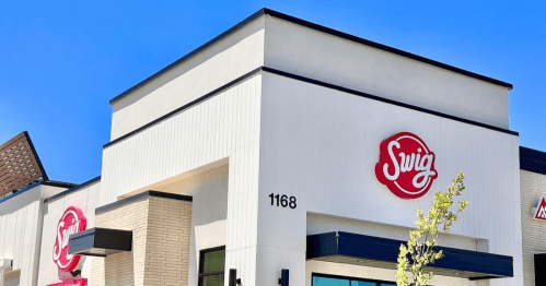 Exterior of a Swig restaurant with a clear blue sky, featuring the logo and address 1168 prominently displayed.