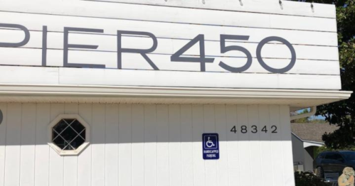 Sign for "Pier 450" on a white building, featuring a handicap accessibility symbol and the number 48342.