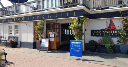 Exterior of Thames Waterside Bar & Grill, featuring a welcoming entrance with plants and signage for specials.
