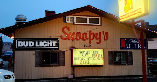 A building with a sign reading "Snoopy's" and festive decorations, advertising a Christmas party.
