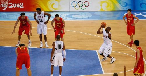 A basketball game featuring USA and China players during the 2008 Olympics, with a player preparing to shoot.