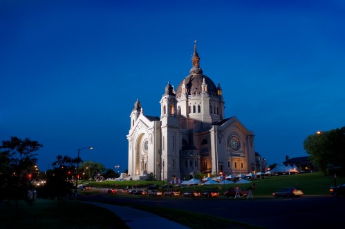 The Cathedral of Saint Paul illuminated at dusk, showcasing its grand architecture against a deep blue sky.