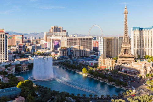 Aerial view of the Las Vegas Strip featuring the Bellagio fountains and the Eiffel Tower replica.