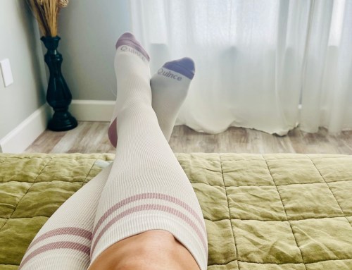 A person's legs in knee-high socks with stripes, resting on a green bedspread, with a soft background and natural light.