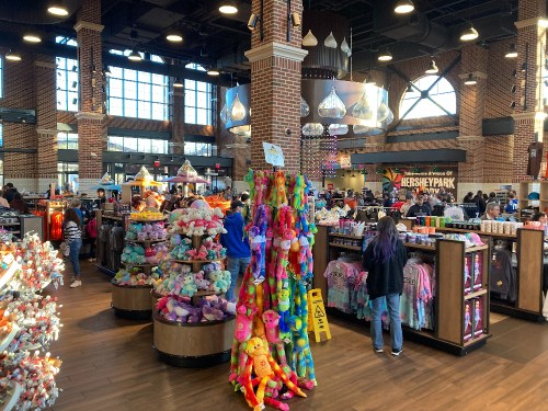 A vibrant gift shop at Hersheypark, filled with colorful merchandise, plush toys, and visitors browsing.