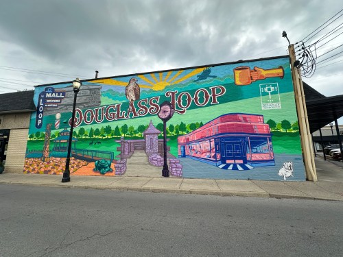 Colorful mural on a building featuring local landmarks and nature, with the text "Douglass Loop" prominently displayed.