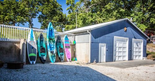 Kayaks lined up on a fence near a waterfront retreat in Missouri, along Lake of the Ozarks