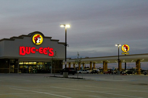 Buc-ee's convenience store and gas station at dusk, featuring bright signage and a spacious parking lot.