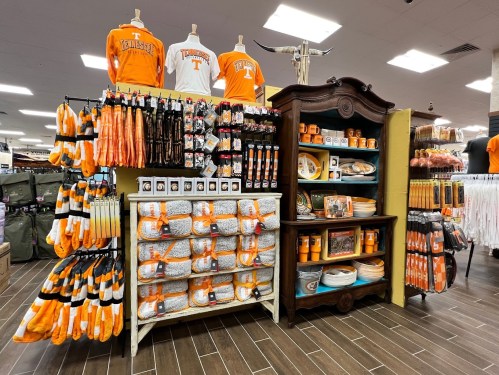Display of orange and white Tennessee merchandise, including clothing, accessories, and home goods in a retail store.