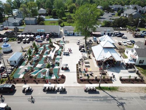 Aerial view of a recreational area with mini-golf, a pavilion, and parked golf carts in a vibrant community setting.