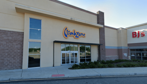 Exterior of a building featuring the "ClimbZone" sign, with a BJ's store visible to the right. Clear blue sky above.
