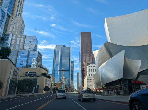 Cityscape featuring modern skyscrapers and unique architectural structures under a blue sky.
