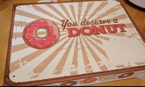 A colorful donut box with the text "You deserve a DONUT" and a large donut graphic on a sunburst background.