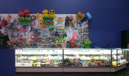 Colorful display of toys and novelty items, including plush toys, candy, and party supplies, in a vibrant store setting.