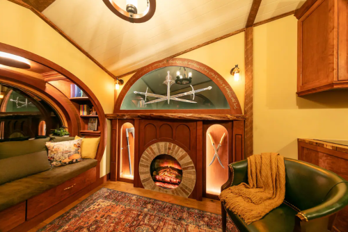 Cozy interior with a fireplace, wooden accents, a plush seating area, and warm lighting.