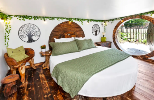 Cozy bedroom with a round bed, wooden decor, green accents, and nature-inspired wall art.