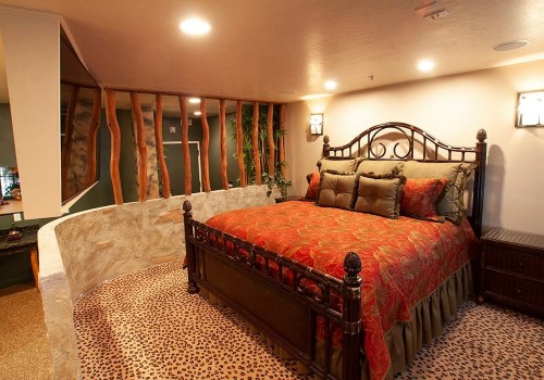 Cozy bedroom with a large bed, decorative bedding, and unique stone and wood accents in a warm, inviting space.