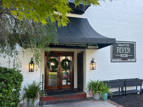 Entrance to the River Room, featuring double doors, a black awning, and decorative wreaths on the door.