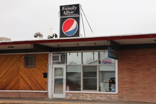 Exterior of The Family Affair Restaurant, featuring a Pepsi sign and large windows, with a "Open" sign visible.
