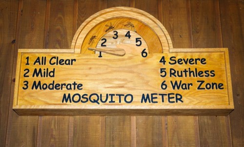 A wooden sign displaying a "Mosquito Meter" with levels from 1 (All Clear) to 6 (War Zone).