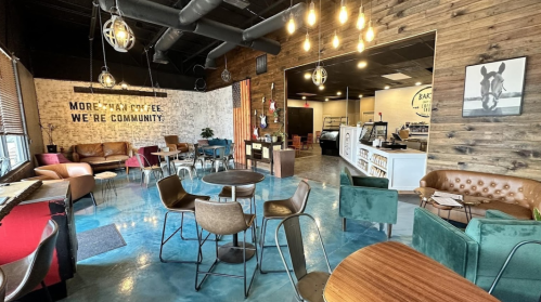 Cozy coffee shop interior with wooden walls, stylish seating, and warm lighting, promoting a sense of community.