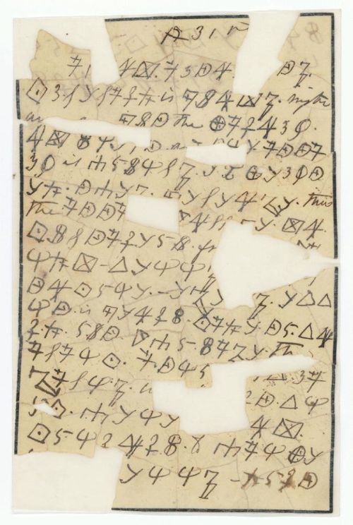 A torn piece of paper covered in handwritten symbols and characters, some resembling geometric shapes and letters.