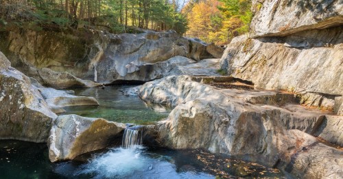 several light-colored giant rocks with water flowing through it