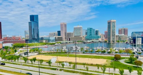 view of baltimore harbor, the national aquarium, a marina, and skyscrapers as seen from baltimore's federal hill neighborhood