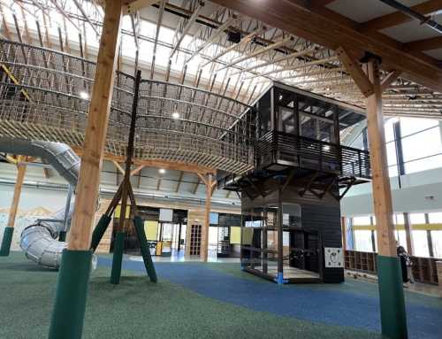 Indoor playground featuring a multi-level play structure, slide, climbing elements, and spacious, bright design.